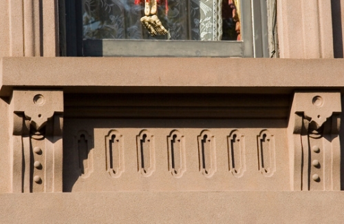 A decorative window featuring ornate trim, enhancing the aesthetic appeal of the surrounding architecture.